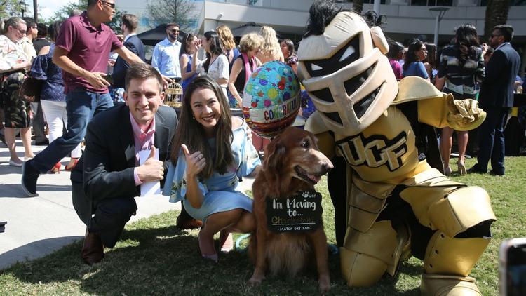 Knightro, dog and two grads on campus