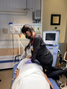 Kaitlyn Yu, a junior UCF nursing student, performing CPR in a simulation lab on a manikin.