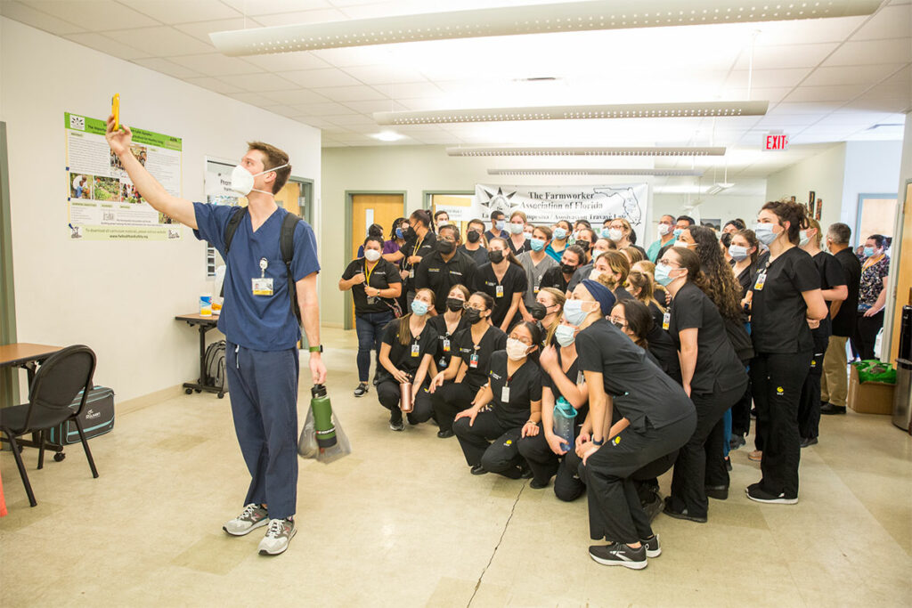 A UCF health sciences student takes a selfie of a group of UCF nursing, medical, health sciences students at the first in-person, interdisciplinary Apopka Farmworkers Clinic since the start of the COVID-19 andemic.