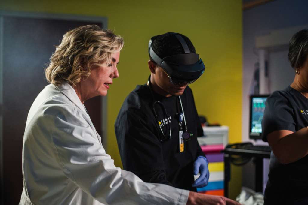 UCF nursing faculty member and student wearing AR/VR goggles learning in the simulation center