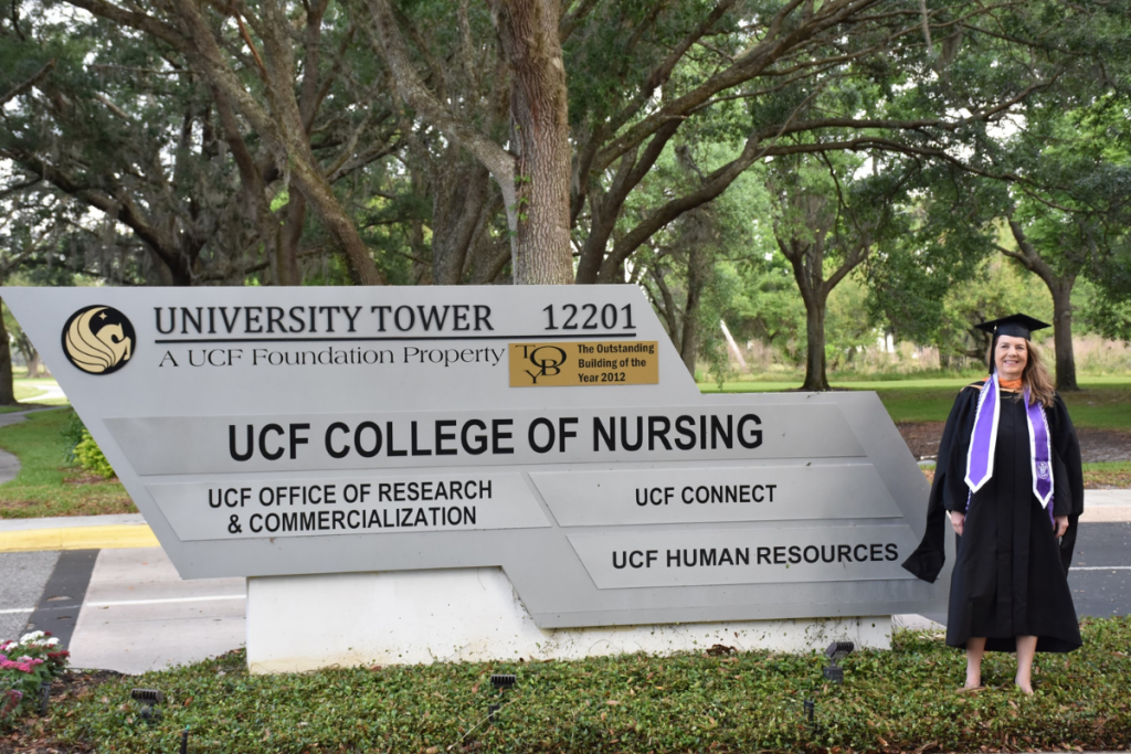 Nadine Jacobson '23MSN in front of the UCF College of Nursing sign in Research Park, Orlando, Florida