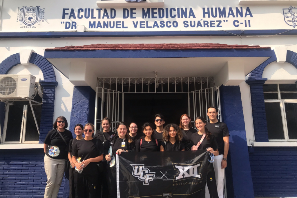 A group of UCF College of Nursing students and faculty holding a UCF banner outside a medical facility in Chiapas, Mexico, during a study abroad trip in 2023