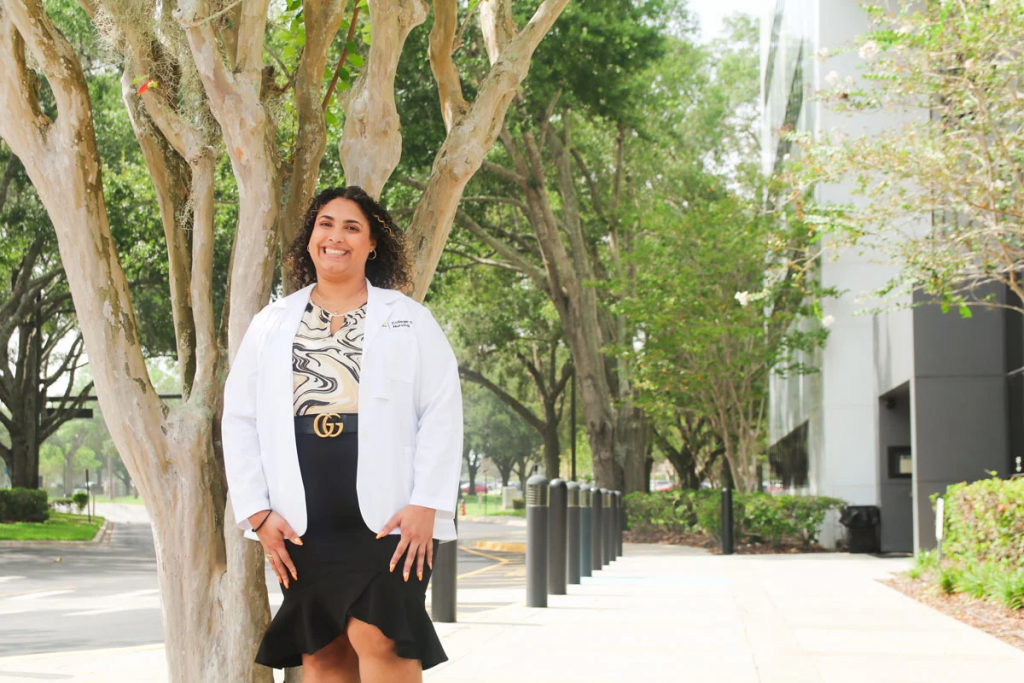 Alumna and academic success tutor Aliyah Gonzalez '21 '23BSN in front of the UCF College of Nursing building in Orlando, Florida