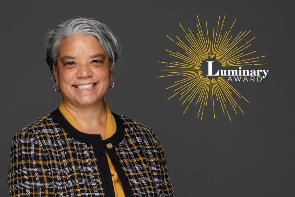 Graphic with left aligned faculty photo of Dr. Desiree Díaz from UCF College of Nursing. UCF Pegasus logo and Luminary Award logo on graphic. All elements on dark gray background.