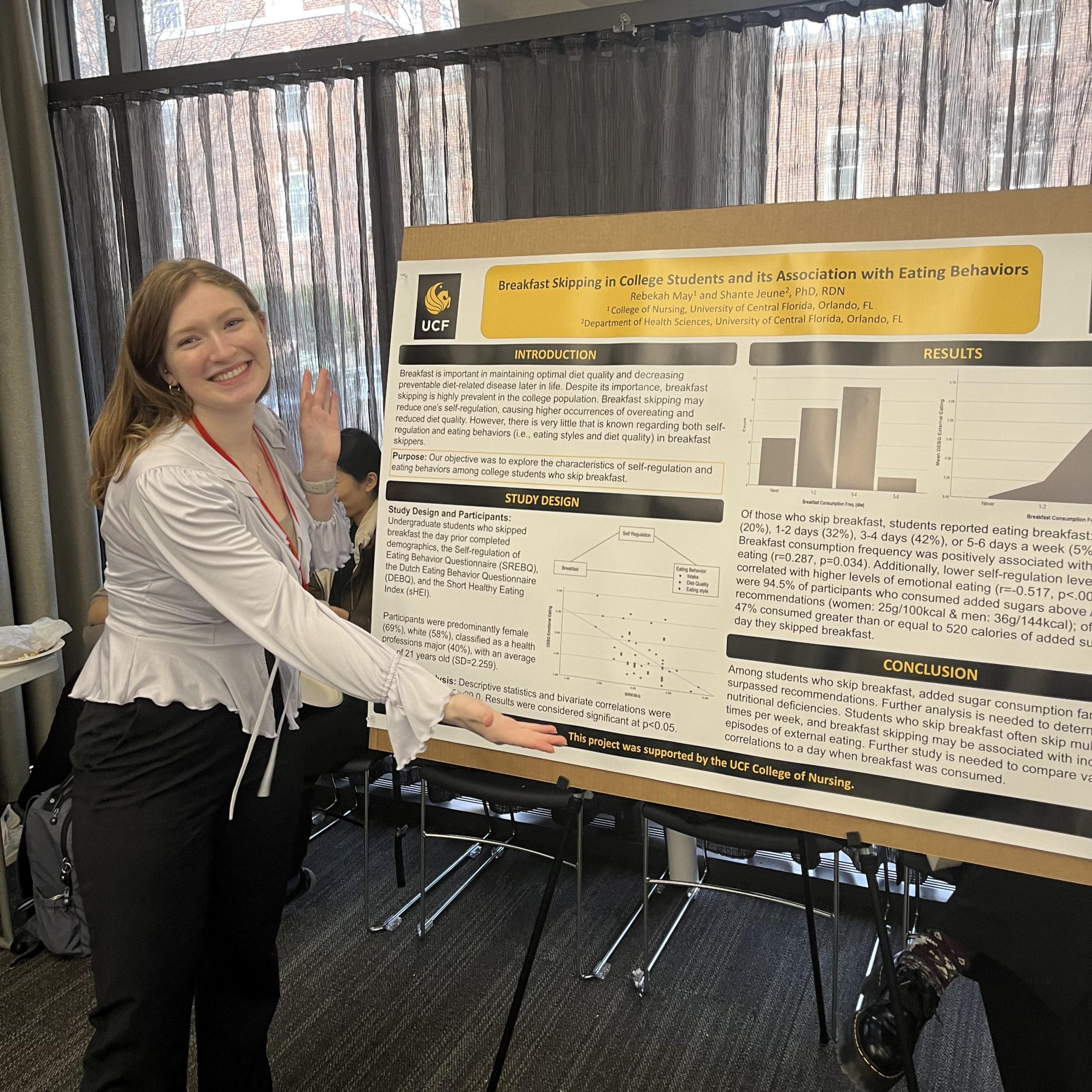 UCF nursing student Rebekah May stands next to a research poster presentation