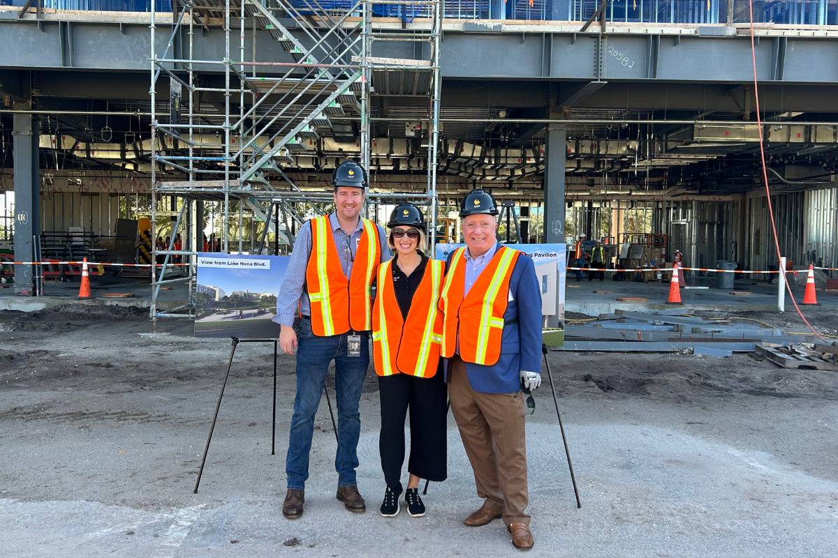 Wearing construction vests, gloves and hard hats, a member of UCF College of Nursing stands next to two members from Addition Financial inside the Dr. Phillips Nursing Pavilion, which is under construction in Orlando, Florida