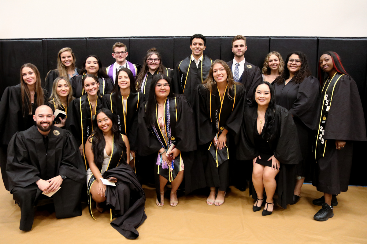 A large group of UCF nursing students in regalia gather together inside The Venue before the Spring 2025 recognition ceremony.