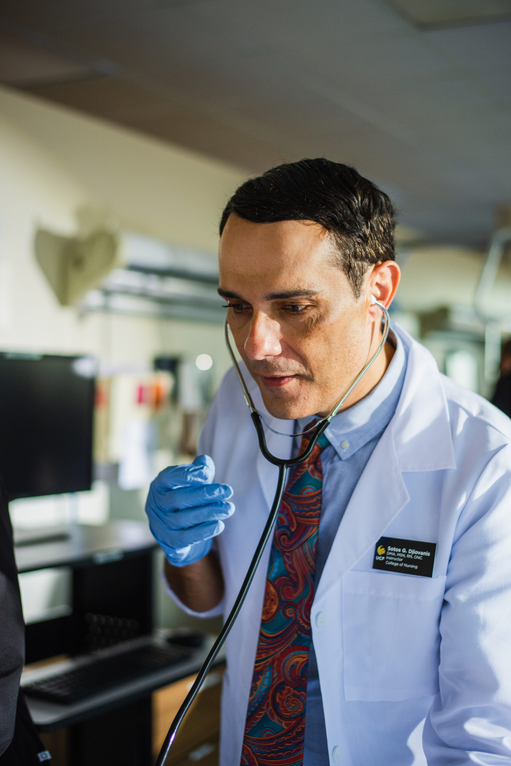 Professor Sotos listening with a stethoscope, focused on a subject.