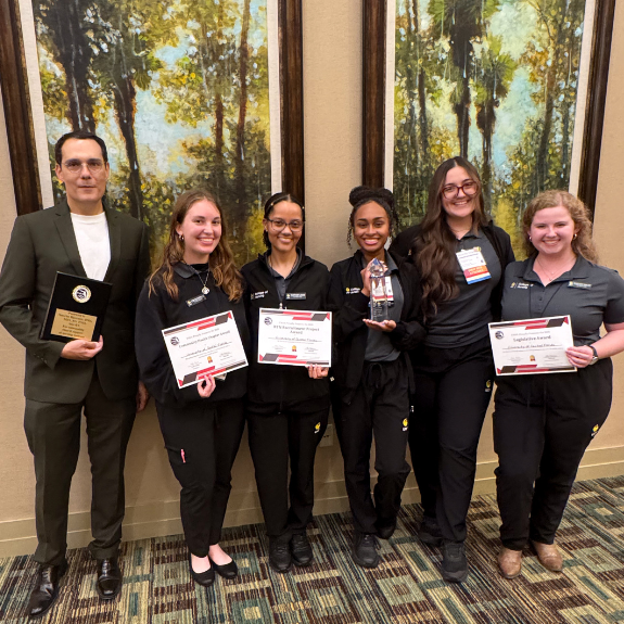 Marion Jones, Brooke Bynum, Alexandria Duran, Allyson Crighton, Aiya Falhi, and Ciaera Ambroise, and Sotos Djiovanis holding awards.