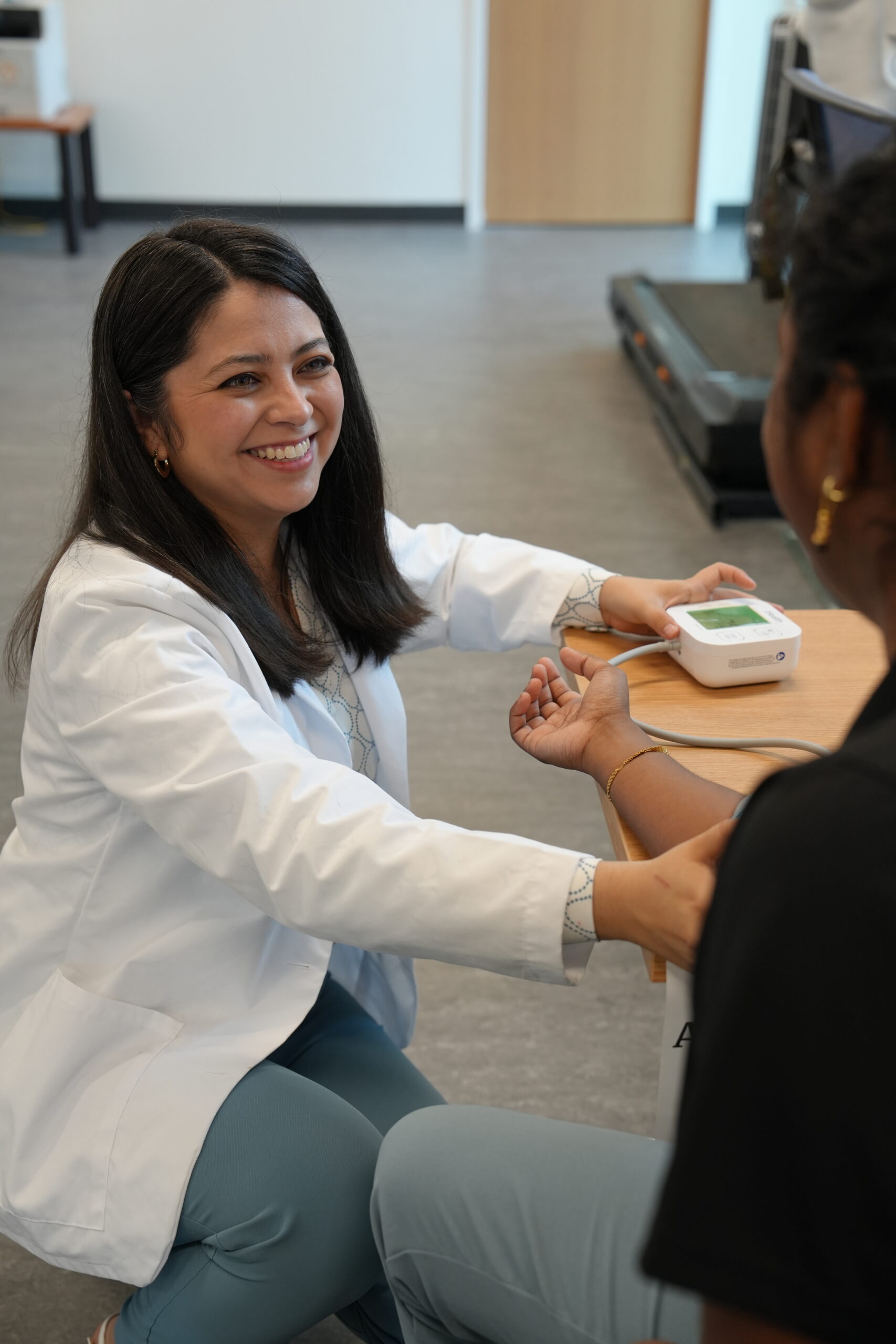 A nursing instructor taking someone's blood pressure.